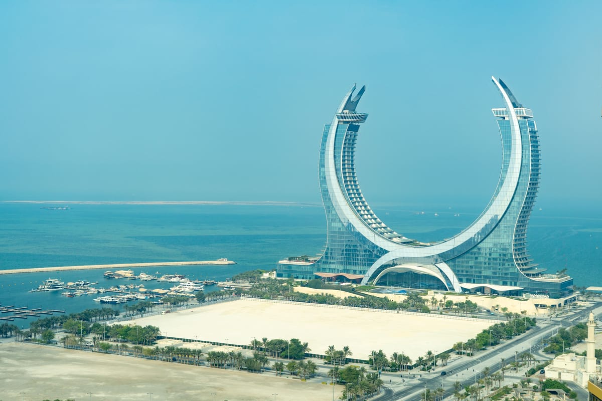 The curved twin towers of Katara Towers at Lusail, the Gulf behind them and the marina below